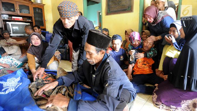 Keluarga histeris melihat jenazah korban longsor di Dusun Cimapag, Desa Sirnaresmi, Kecamatan Cisolok, Sukabumi, Selasa (1/1). Longsor mengakibatkan 30 rumah yang dihuni 107 jiwa tertimbun. (merdeka.com/Arie Basuki)