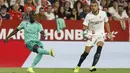 Bek Real Madrid, Ferland Mendy (kiri) mengumpan bola dari kawalan pemain Sevilla, Joan Jordan selama pertandingan lanjutan La Liga Spanyol di stadion Ramon Sanchez Pizjuan di Seville (22/9/2019). Real Madrid menang tipis atas Sevilla 1-0. (AP Photo/Miguel Morenatti)