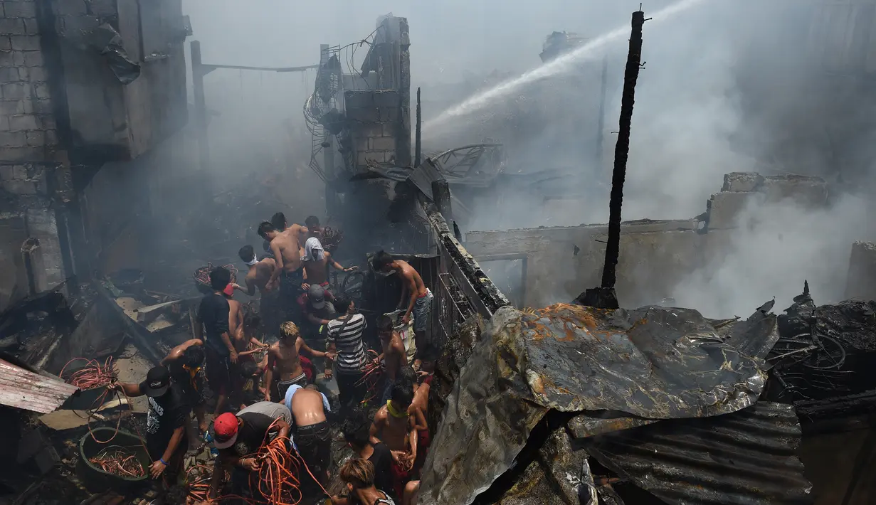 Warga berdesakan untuk mengumpulkan sisa kabel listrik serta barang yang masih terpakai usai kebakaran pemukiman padat penduduk dekat pelabuhan di Manila, Filipina, Selasa (9/5). Mereka berebut mengumpulkan tembaga dari sisa kabel listrik (TED ALJIBE/AFP)