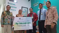 Regional Sales Head Sharia PT AXA Mandiri Financial Services (AXA Mandiri) Yusuf Maulana (ketiga kanan) bersama Area Manager Bank Syariah Indonesia (BSI) Banjarmasin Naning Salasatain (kiri) menyerahkan klaim asuransi meninggal dunia kepada Novitasari, istri almarhum Abdul Aziz Kamarullah, nasabah AXA Mandiri (kedua kiri) di Pangkalan Bun, Kalimantan Tengah (22/11/22) (Liputan6.com)