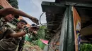 Petugas PLN dibantu petugas Kecamatan Johar Baru memutus kabel saluran listrik ilegal di Johar Baru, Jakarta Pusat, Rabu (25/3/2015). Kegiatan itu untuk mengurangi saluran listrik ilegal dan mencegah kebakaran.   (Liputan6.com/Faizal Fanani)
