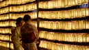 Dua wanita berada di depan lentera saat menghadiri Festival Mitama di Kuil Yasukuni, Tokyo, Jepang, (13/7). Acara ini menghadirkan sekitar 30.000 lentera untuk mengenang korban perang.  (AFP Photo/Toru Yamanka)