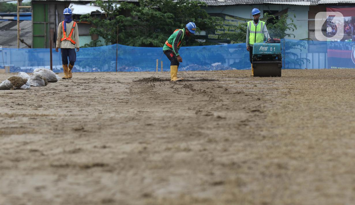 Pekerja melakukan perataan tanah di area lapangan latih Jakarta International Stadium, Jumat (23/10/2020). Nantinya lapangan latihan ini akan ditumbuhi rumput hybrid, yang memiliki komposisi 5 persen rumput sintetis dan 95 persen natural berjenis Zoysia Matrella. (Liputan6.com/Helmi Fithriansyah)