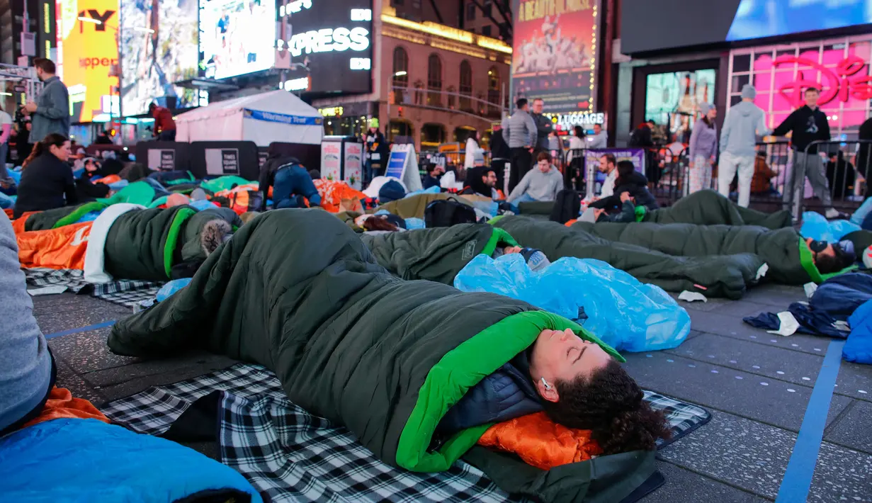 Para aktivis menggelar aksi dengan beralaskan kantong tidur. (KENA BETANCUR/AFP)