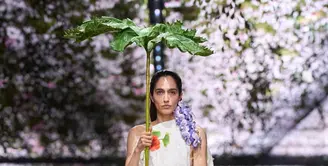 Alih-alih menampilkan kemewahan couture secara konvensional, Anderson mengubah ruang peragaan yang berlokasi di Musée Rodin menjadi lanskap yang terasa hidup. Bunga-bunga digantung di udara, menciptakan kesan seolah alam perlahan mengambil alih ruang couture. [Dok/DIOR].