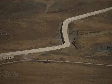 Tembok pembatas sedang didirikan di sepanjang perbatasan antara Turki dan Iran, di Provinsi Van, Turki timur, Kamis (19/8/2021). Turki memperkuat perbatasannya dengan Iran untuk menghalau arus pengungsi dari Afghanistan yang melarikan diri setelah negara itu dikuasai Taliban. (AP Photo/Emrah Gurel)