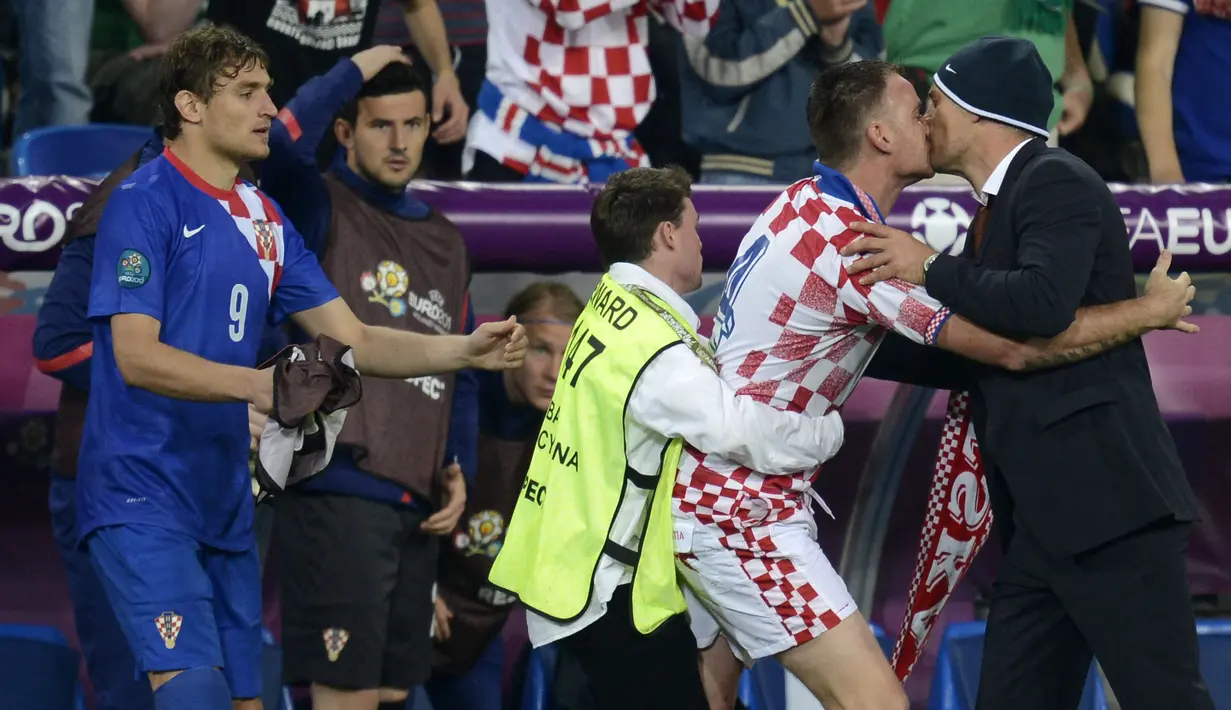 Fan Kroasia berhasil menyusup ke lapangan hijau di laga Irlandia vs Kroasia Piala Eropa 2012 dan berusaha mencium Slaven Billic pelatih Kroasia. ( AFP/Odd Andersen )
