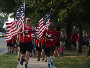 Sejumlah warga yang tergabung dalam kelompok veteran berlari sambil membawa bendera Amerika Serikat untuk menunjukan solidaritas terkait penembakan di Virginia, AS (14/6). (Alex Wong/Getty Images/AFP)