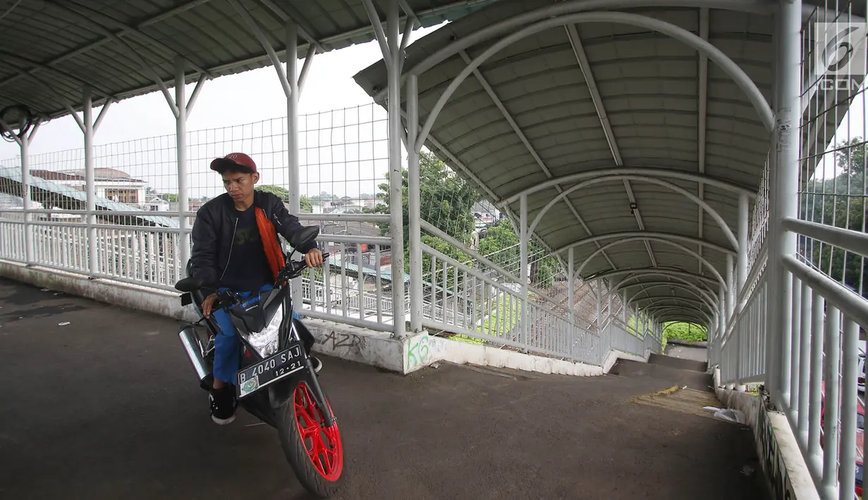 Pengendara motor memanfaatkan JPO (jembatan penyeberangan orang) di kawasan Pasar Minggu, Jakarta, Selasa (17/10). Aksi tidak tertib tersebut mengganggu hak pejalan kaki dan berpotensi membahayakan pengguna JPO. (Liputan6.com/Immanuel Antonius)