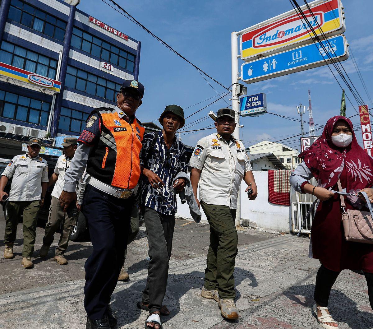 Petugas Dinas Perhubungan DKI Jakarta bersama Satpol PP mengamankan seorang juru parkir (jukir) liar di sebuah minimarket di bilangan Jakarta Pusat, Rabu (15/5/2024). Penertiban jukir liar yang menjamur di berbagai lokasi, utamanya minimarket, ini dilakuk