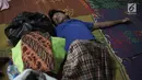 Seorang pengungsi pria yang rumahnya terendam banjir tertidur saat mengungsi di Kelurahan Kampung Melayu, Jatinegara, Jakarta Timur, Rabu (7/2). Warga tidur hanya beralaskan tikar dan berselimut kain tipis. (Liputan6.com/Arya Manggala)