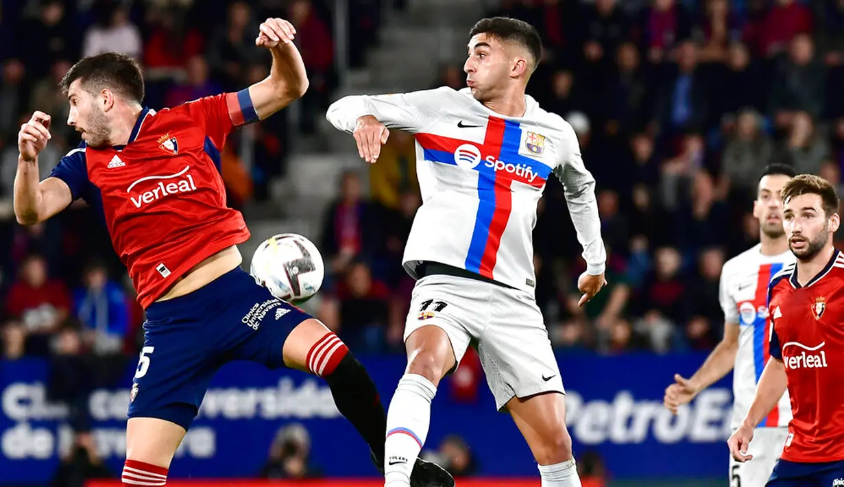 Pemain Osasuna David Garcia (kiri) berebut bola udara dengan pemain Barcelona Ferran Torres pada pertandingan sepak bola Liga Spanyol di Stadion El Sadar, Pamplona, Spanyol, 8 November 2022. Barcelona menang 2-1. (AP Photo/Alvaro Barrientos)