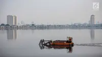 Kapal tongkang Dinas Tata Air DKI Jakarta mengeruk lumpur dan sampah dari Waduk Pluit, Jakarta, Selasa (11/12). Pengerukan ini juga untuk mencegah pertumbuhan eceng gondok yang mengakibatkan pendangkalan Waduk Pluit. (Liputan6.com/Faizal Fanani)
