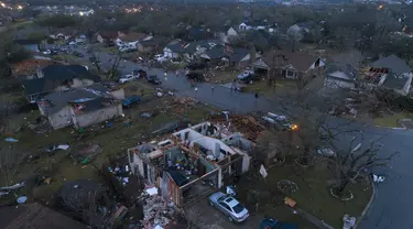 Puing-puing berserakan di tanah di sekitar rumah, yang rusak akibat tornado, di Oxford Drive dan Stratford Drive di Round Rock, Texas, Senin (21/3/2022). (Jay Janner/Austin American-Statesman via AP)