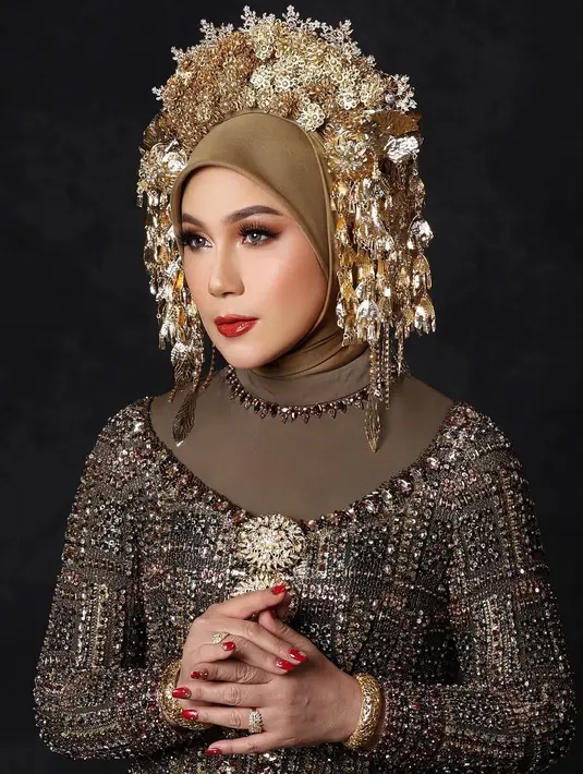 Dengan makeup bold berlipstik merah, Marini Zumarnis lengkapi tampilan dengan suntiang di atas hijab [@marinizumarnisreal]