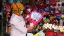 Penjual menujukkan bunga mawar yang dihias dengan boneka,uang dan coklat di Rawa Belong, Jakarta, Senin (14/2/2022). Hari Valentine yang diperingati setiap 14 Februari menjadi berkah bagi para penjual bunga karena banyak pesanan bunga di momen kasih sayang tersebut. (Liputan6.com/Angga Yuniar)