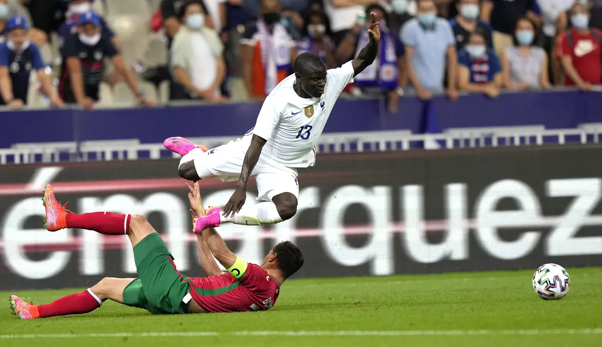 Gelandang timnas Prancis, N'Golo Kante berebut bola dengan bek Bulgaria, Vasil Bozhikov pada laga uji coba menjelang Piala Eropa 2020 di Stade de France, Rabu (9/6/2021) dini hari WIB. Timnas Prancis menaklukkan Bulgaria dengan skor meyakinkan 3-0. (AP Photo/Francois Mori)
