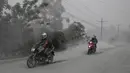 Pengendara motor melintasi jalan yang tertutup abu vulkanik dari gunung Taal untuk mengungsi di Lemery, provinsi Batangas, Filipina, Senin (13/11/2020). Erupsi gunung Taal memaksa puluhan ribu orang mengungsi serta membuat sekolah-sekolah dan toko di Manila tutup. (AP/Aaron Favila)
