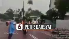 Detik-detik petir dahsyat menyambar sebuah jalan yang saat kejadian itu sedang diguyur hujan.