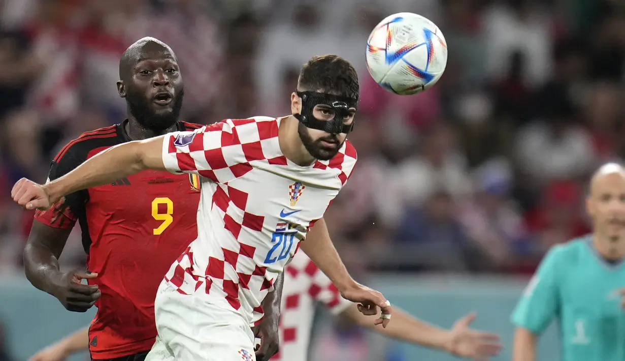 Bek Kroasia Josko Gvardiol melakukan sundulan saat bertahan melawan penyerang Belgia Romelu Lukaku pada laga terakhir Grup F Piala Dunia 2022 di Stadion Ahmad bin Ali, Kamis (1/12/2022). Josko Gvardiol sukses membuat Romelu Lukaku gagal melesatkan satu gol pun ke gawang Kroasia.