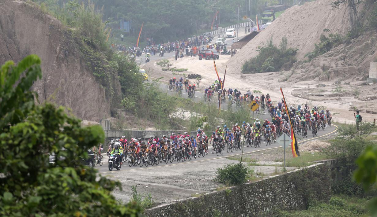 Aksi para pebalap sepeda selepas start dari Kantor Bupati Padang Pariaman dalam Etape 2 Tour de Singkarak 2015, Minggu (4/10/2015). (Bola.com/Arief Bagus)