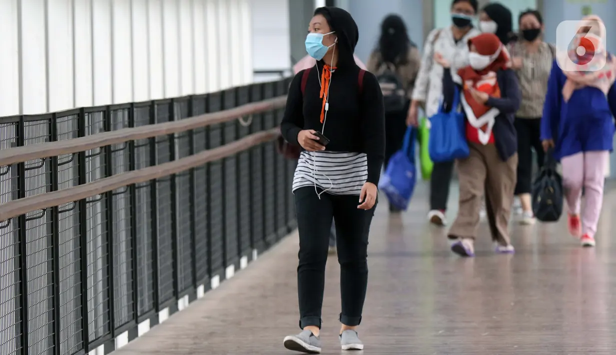 Warga menggunakan masker berjalan di JPO kawasan Jalan Jenderal Sudirman, Jakarta, Kamis (10/9/2020). Setelah mempertimbangkan sejumlah faktor, di antaranya ketersediaan tempat tidur rumah sakit, PSBB DKI Jakarta kembali diperketat per Senin (14/9). (Liputan6.com/Helmi Fithriansyah)