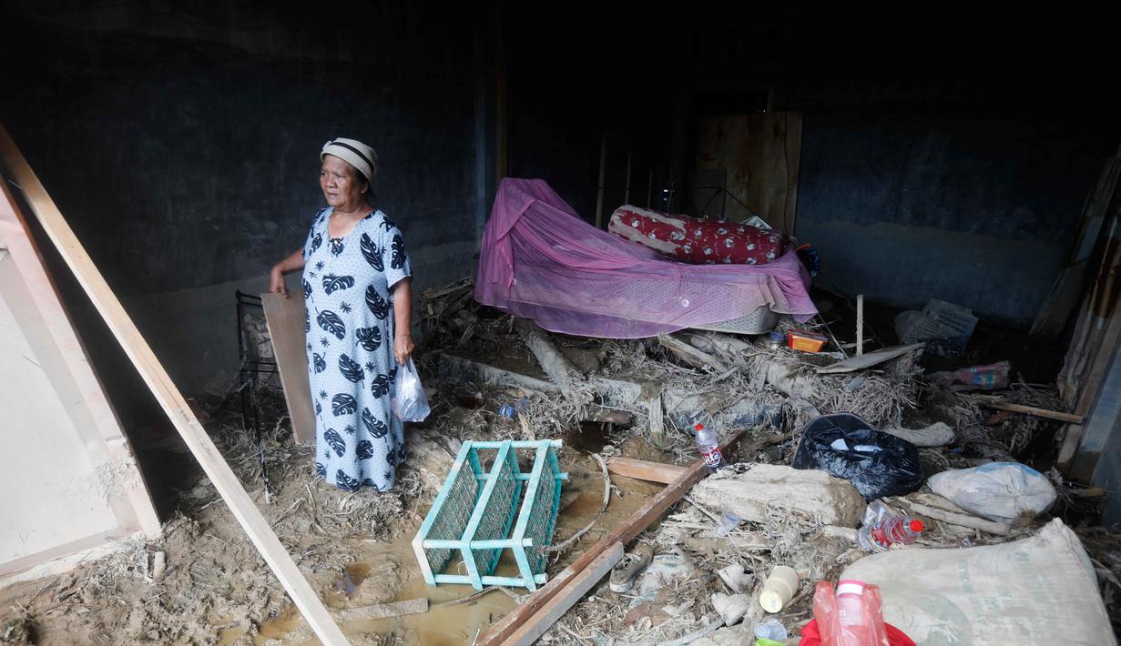 BPBD bersama perangkat kecamatan masih melakukan pendataan menyeluruh untuk memastikan skala kerusakan. Tampak dalam foto, seorang perempuan berdiri di dalam rumahnya yang rusak di sebuah desa yang terdampak banjir bandang di Batang Toru, Sumatera Utara, Senin 1 Desember 2025. (AP Photo/Binsar Bakkara)