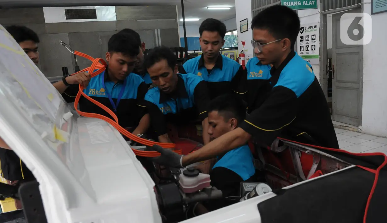 Pelajar SMK Negeri 26 Jakarta melakukan pengecekan instalasi part konversi mobil listrik di Bengkel Otomotif SMKN 26, Jakarta, Rabu (13/5/2023). (merdeka.com/Imam Buhori)