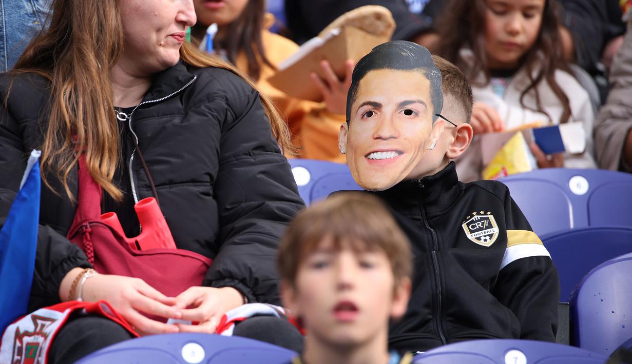 Seorang suporter mengenakan topeng Cristiano Ronaldo saat menyaksikan laga Grup F Kualifikasi Piala Dunia 2026 antara Portugal melawan Armenia di Dragao Stadium, Porto, Minggu (16/11/2025) waktu setempat. (AP Photo/Luis Vieira)