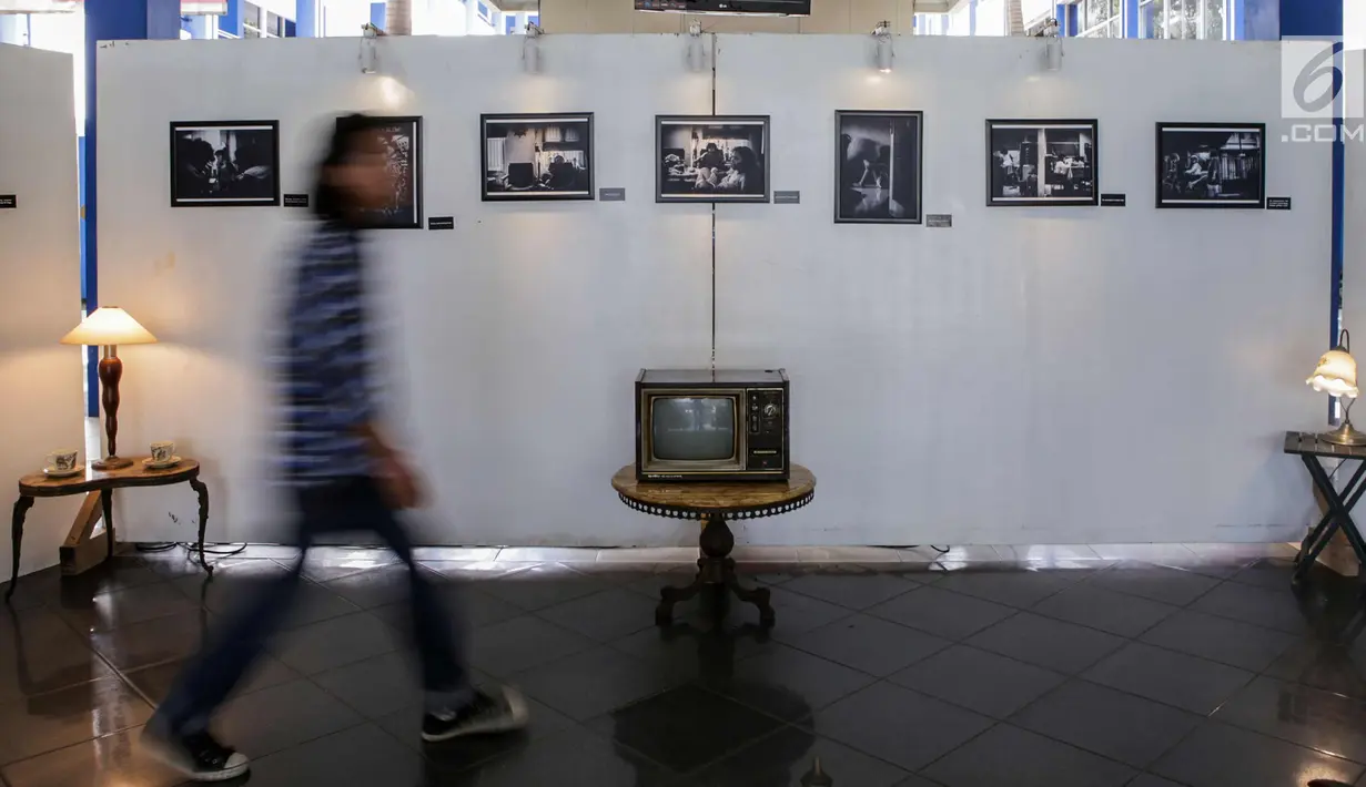 Pengunjung melintas di depan karya foto selama pameran fotografi di Kampus Universitas Budi Luhur, Jakarta, Jumat (27/10). Pameran fotografi ini bertemakan 'Kebebasan Yang Dirindukan' menampilkan 17 karya foto. (Liputan6.com/Angga Yuniar)