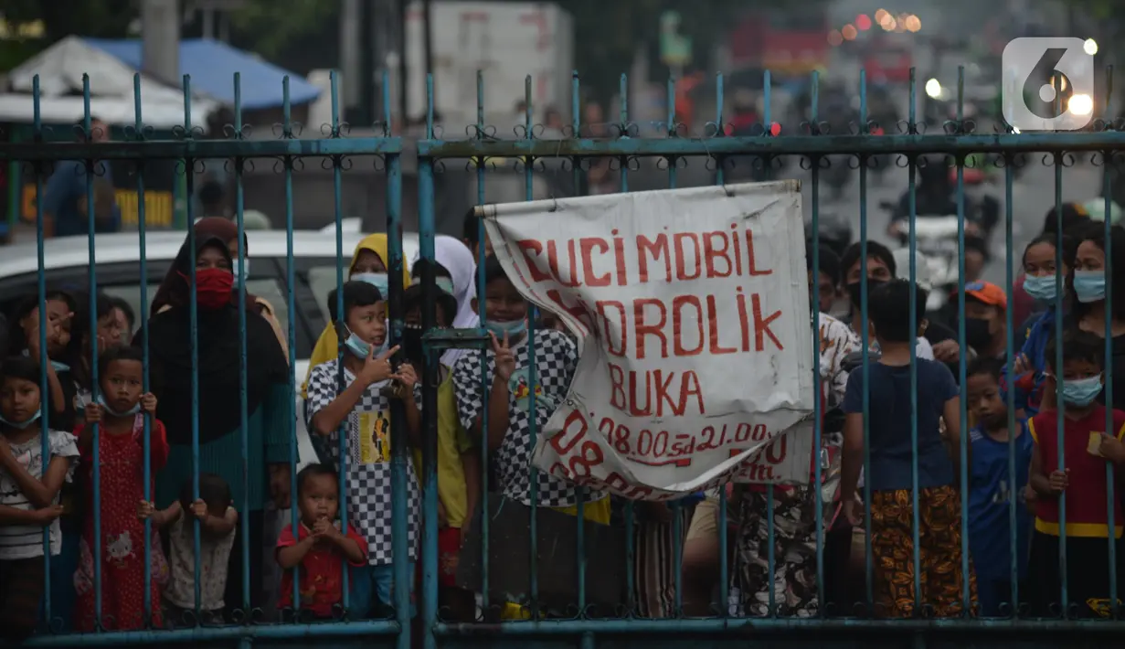 Warga menunggu antrean masuk pembagian makan gratis di Posko Perjuangan Rakyat (POSPERA), Jakarta, Rabu (10/3/2021). Pembagian 500 nasi bungkus beserta masker dan vitamin secara gratis setiap harinya dalam bentuk meringankan beban warga di tengah pandemi Covid-19. (merdeka.com/Imam Buhori)