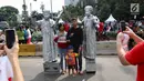 Warga sedang berfoto dengan seniman yang memerankan Pangeran Diponegoro dan Imam Bonjol saat kegiatan Car Free Day di Bundaran HI di Jakarta, Minggu, (12/11). Mereka membuka kesempatan kepada warga yang ingin foto bersama. (Liputan6.com/Fery Pradolo)