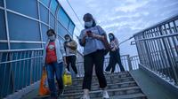 Orang-orang berjalan melintasi jembatan penyeberangan di lingkungan dengan dugaan kasus virus corona di Beijing (15/9/2021). China memperketat penguncian dan meningkatkan pesanan untuk pengujian massal di kota sepanjang pantai timurnya di tengah lonjakan kasus COVID-19. (AP Photo/Mark Schiefelbein)