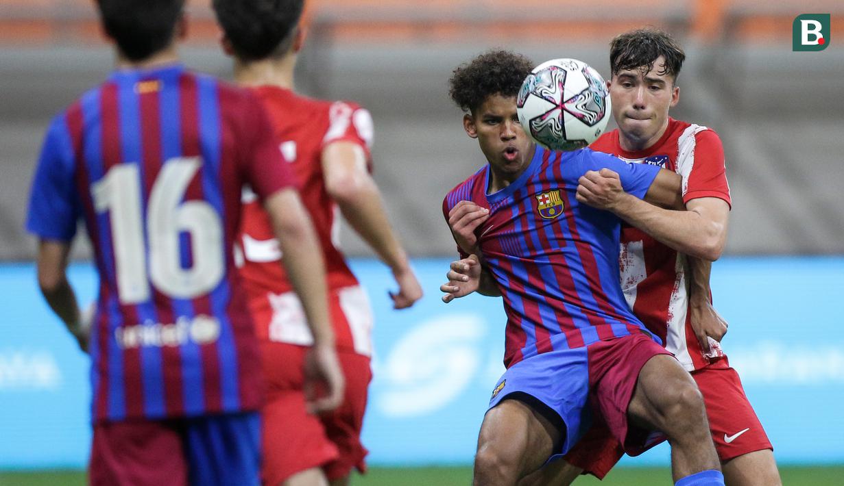 Pemain Barcelona U-18, Jorge Javier Espinal Diaz (kiri) berebut bola dengan pemain Atletico Madrid U-18, Mario Caballero Bueno saat laga International Youth Championship 2021 di Jakarta International Stadium, Jakarta, Jumat (15/04/2022). (Bola.com/Bagaskara Lazuardi)