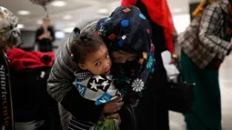 Zahra Warsma memeluk cucunya setelah berpergian bersama sang ibu dari Somalia, setibanya di Bandara Dulles, Washington, Senin (6/2). Sejumlah warga muslim sempat tidak dapat masuk AS akibat kebijakan imigrasi Donald Trump. (Win McNamee/Getty Images/AFP)