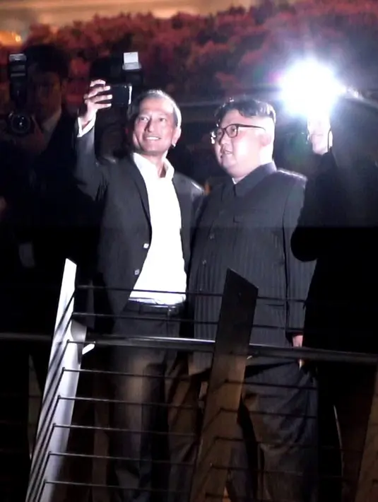 Menteri Luar Negeri Singapura, Vivian Balakrishnan berswafoto dengan pemimpin Korea Utara, Kim Jong-un di Gardens by the Bay, Senin (11/6). Kim mengunjungi sejumlah tempat wisata di Singapura sebelum pertemuannya dengan Donald Trump. (AFP/Nicholas Yeo)