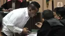 Salah satu terdakwa kasus penyiraman Novel Baswedan berdiskusi dengan kuasa hukum disela sidang perdana di Pengadilan Negeri Jakarta Utara, Kamis (19/3/2020). Dua terdakwa, yakni Ronny Bugis dan Rahmat Kadir Mahulete menjalani sidang dengan agenda pembacaan dakwaan. (merdeka.com/Iqbal Nugroho)