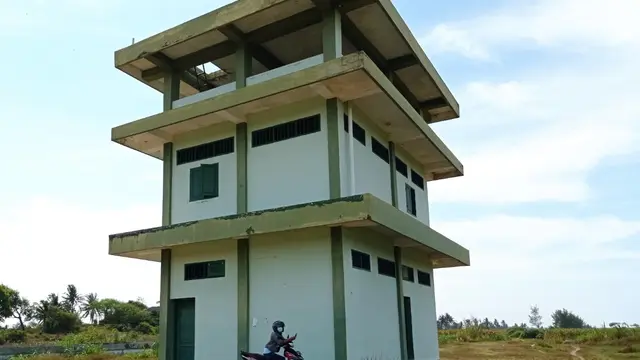 Seorang warga berada di depan gedung tiga lantai bekas gudang senjata di Desa Setrojenar, Kecamatan Buluspesantren yang dibangun TNI AD di atas tanah bersertifikat hak milik atas nama Mihad, Rabu (24/3/2021). (Foto: Liputan6.com/Rudal Afgani )