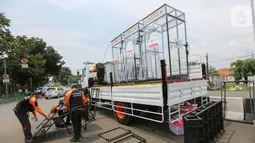 Relawan Dompet Dhuafa memasang tangga untuk masyarakat yang akan menggunakan bilik disinfektan chamber di CheCk Point PSBB, perbatasan Jakarta - Tangsel, Pasar Jumat, Kamis (16/4/2020). Disinfektan chamber aman bagi manusia karena menggunakan cairan antiseptik. (Liputan6.com/Fery Pradolo)