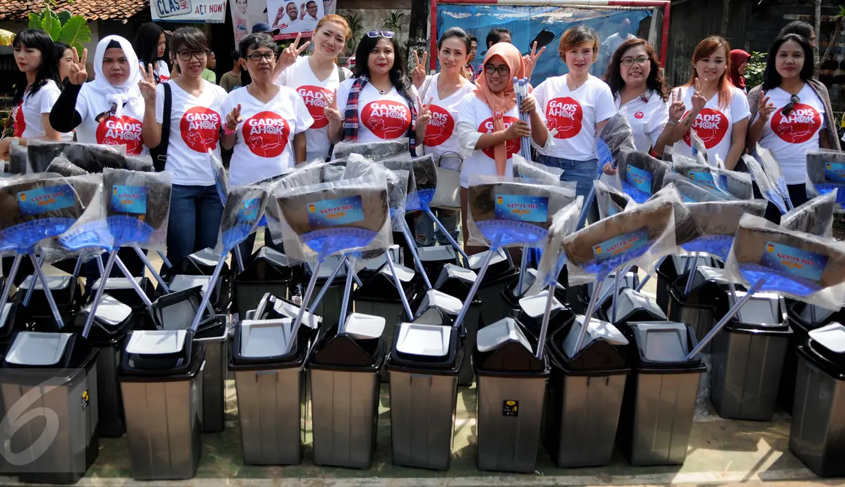 Relawan dari Gerakan Aksi Srikandi Coblos Ahok (Gadis Ahok) foto bersama dengan warga saat mendatangi kawasan Cipete, Jakarta Selatan, Senin (26/12). Mereka juga ikut membersihkan lingkungan sekitar di kawasan tersebut. (Liputan6.com/Gempur M Surya)