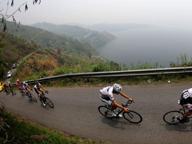Para pebalap sepeda melewati tanjakan di samping Danau Singkarak dalam Etape 4 Tour de Singkarak 2015 antara Sawahlunto-Solok Selatan, Selasa (6/10/2015). (Bola.com/Arief Bagus)