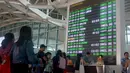 Sejumlah penumpang mencari informasi jadwal penerbangan di Bandara Ngurah Rai, Bali, Jumat (29/6). PT Angkasa Pura I menutup sementara operasional bandara selama 16 jam dikarenakan dampak abu vulkanik Gunung Agung. (AFP/GEDE ARDIASA)