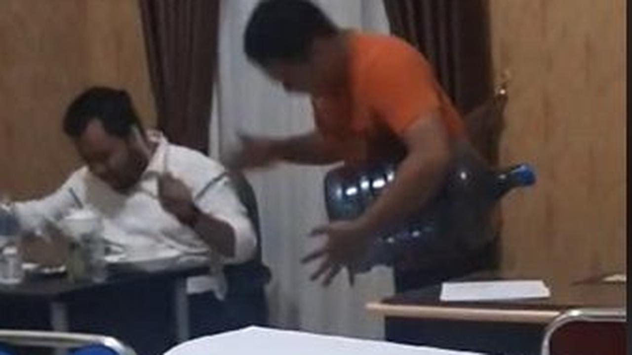 Seorang pria berkaos orange, terlihat menabuh galon sebagai iringan musik.