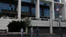 Petugas kepolisian mencari barang bukti usai ledakan bom di Pengadilan Banding di Athena, Jumat, (22/12). Polisi Yunani melaporkan tidak ada korban jiwa akibat kejadian tersebut. (AP Photo / Thanassis Stavrakis)