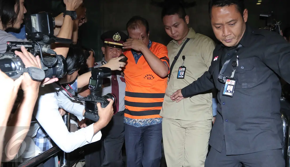 Staf Ahli Anggota DPR Dewie Yasin Limpo, Bambang Wahyuhadi menutup wajahnya usai pemeriksaan di KPK, Jakarta, Kamis (22/10). Bambang resmi ditahan terkait dugaan suap proyek pengembangan pembangkit listrik mikrohidro Papua. (Liputan6.com/Angga Yuniar)
