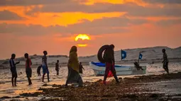 Sejumlah warga berkumpul saat matahari terbenam di Pantai Jazera di pinggiran Mogadishu, Somalia (24/11). Pantai ini jadi tempat rekreasi populer bagi warga Somalia. (AFP Photo/Mohamed Abdiwahab)