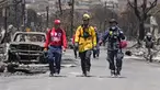 Anggota tim SAR berjalan melewati sisa-sisa kerusakan parah akibat kebakaran hutan di Lahaina, Hawaii, Amerika Serikat, Sabtu (12/8/2023). Jumlah korban tewas akibat kebakaran hutan Hawaii sekarang mencapai 89 orang, kata para pejabat pada Sabtu 12 Agustus 2023 waktu setempat. (AP Photo/Rick Bowmer)