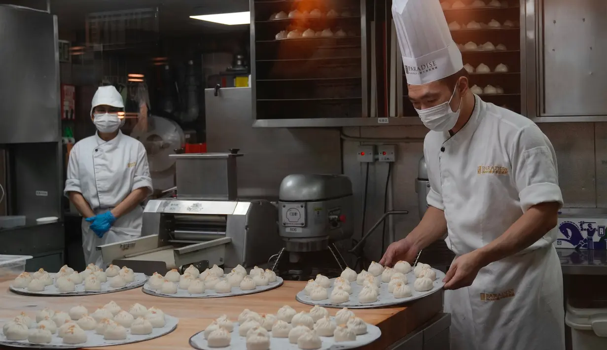 Seorang koki menyiapkan dim sum di sebuah restoran China di Hong Kong (14/1/2022). Penangguhan sementara penumpang transit berlaku pada 16 Januari 2022 - 15 Februari 2022. (AP Photo/Kin Cheung)