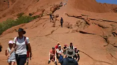 Wisatawan mendaki Uluru yang juga dikenal sebagai Batu Ayers di Taman Nasional Uluru-Kata Tjuta, utara Australia, Jumat (25/10/2019). Kawasan wisata bukit batu Uluru dipenuhi pengunjung, lantaran hari ini merupakan hari terakhir sebelum larangan pendakian diberlakukan. (SAEED KHAN / AFP)