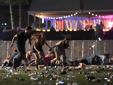 Sejumlah pengunjung berlari dari festival musik Route 91 Harvest country setelah aksi penembakan di Las Vegas, Nevada (1/10). Penembakan dilaporkan terjadi di areal Kasino Mandalay Bay, Las Vegas, Amerika Serikat. (David Becker/Getty Images/AFP)